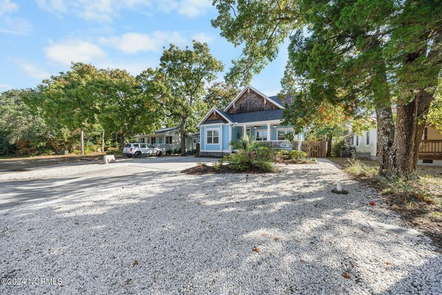 112 NE 28th St, Oak Island, NC 28465 - view of front facade featuring gravel driveway and a porch
