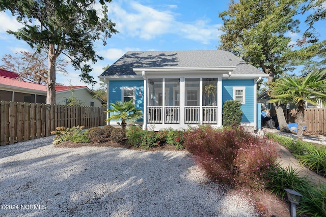 112 NE 28th St, Oak Island, NC 28465 - view of front of property with roof with shingles and a sunroom