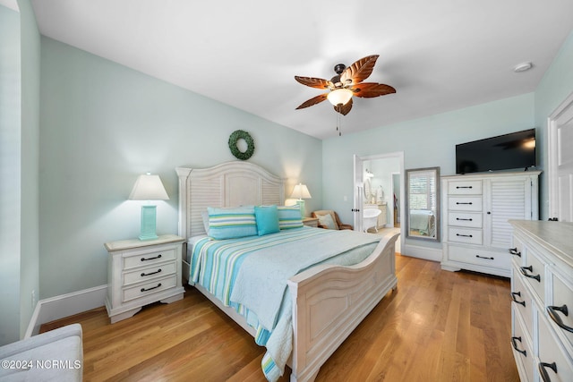 112 NE 28th St, Oak Island, NC 28465 - bedroom with light wood finished floors, ceiling fan, baseboards, and ensuite bathroom