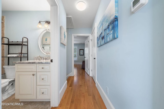 112 NE 28th St, Oak Island, NC 28465 - hall with attic access, a sink, light wood finished floors, and baseboards