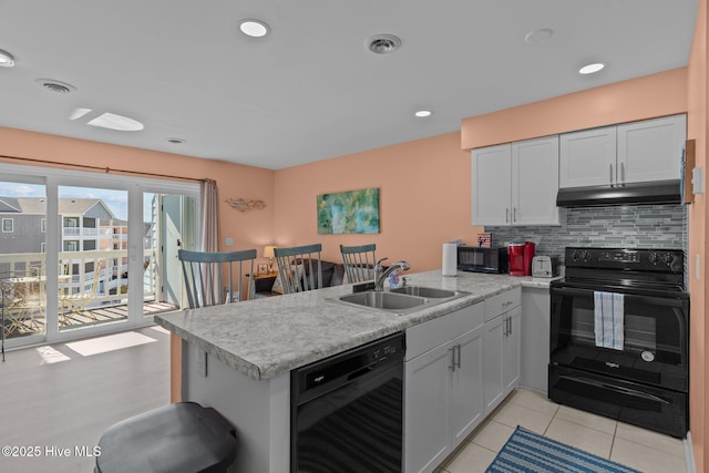 kitchen with white cabinetry, kitchen peninsula, tasteful backsplash, black appliances, and sink