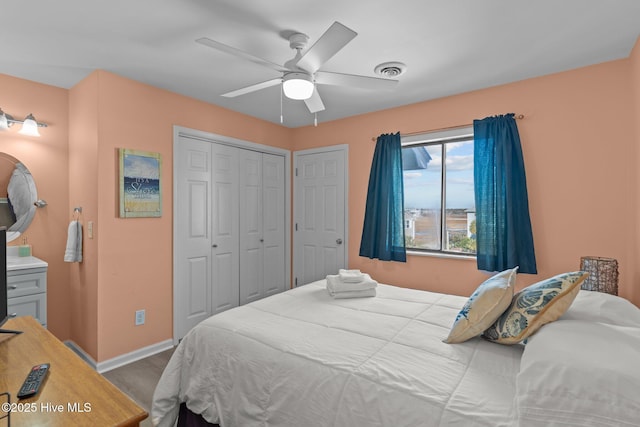 bedroom with ceiling fan and multiple closets