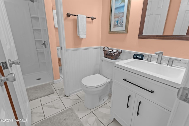 bathroom featuring toilet, a tile shower, and vanity