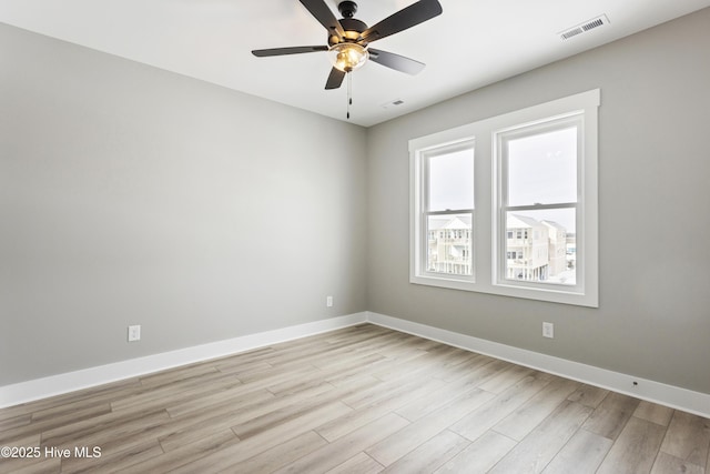 unfurnished room with light wood finished floors, baseboards, visible vents, and a ceiling fan