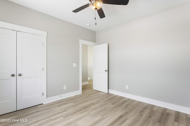 unfurnished bedroom featuring light wood-type flooring, ceiling fan, baseboards, and a closet