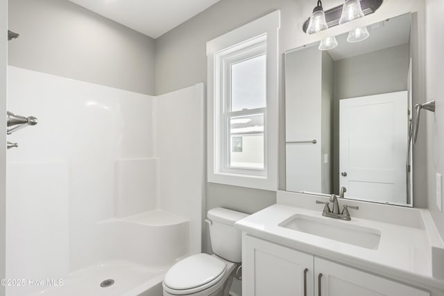 bathroom featuring a shower, vanity, and toilet