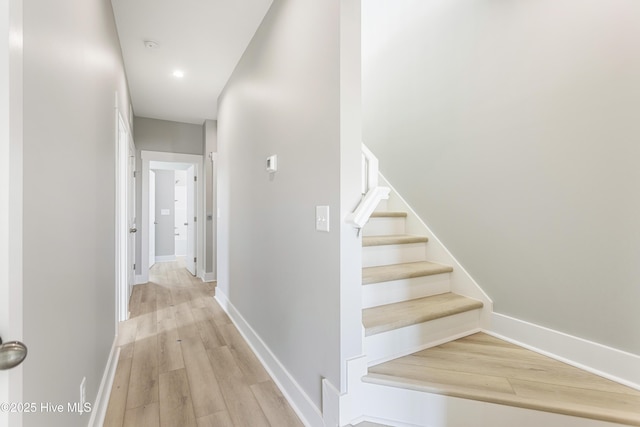 stairs featuring baseboards, wood finished floors, and recessed lighting