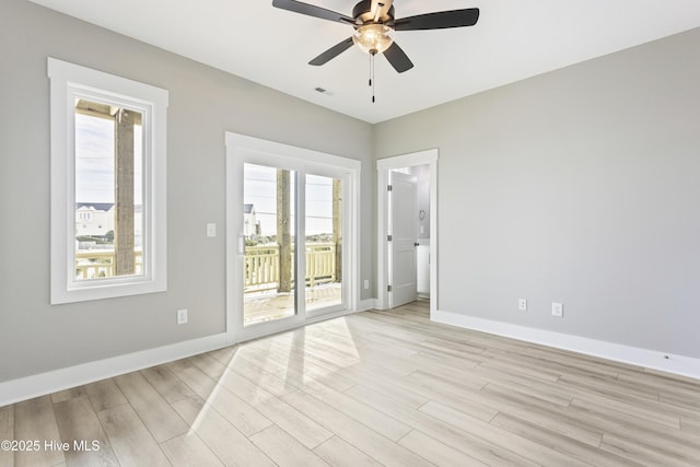 spare room with ceiling fan, baseboards, visible vents, and light wood-style flooring