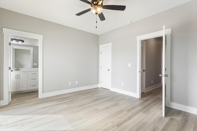 unfurnished bedroom with ensuite bath, light wood-style flooring, and baseboards