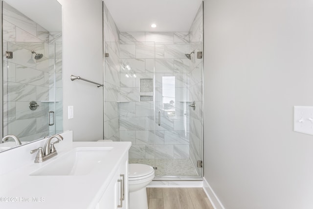 bathroom featuring toilet, a shower stall, vanity, and baseboards