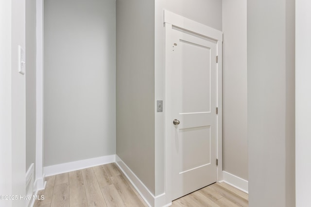 hallway with light wood-style flooring and baseboards