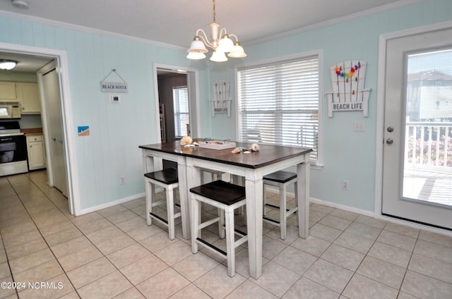 dining space with light tile patterned floors, crown molding, and a wealth of natural light