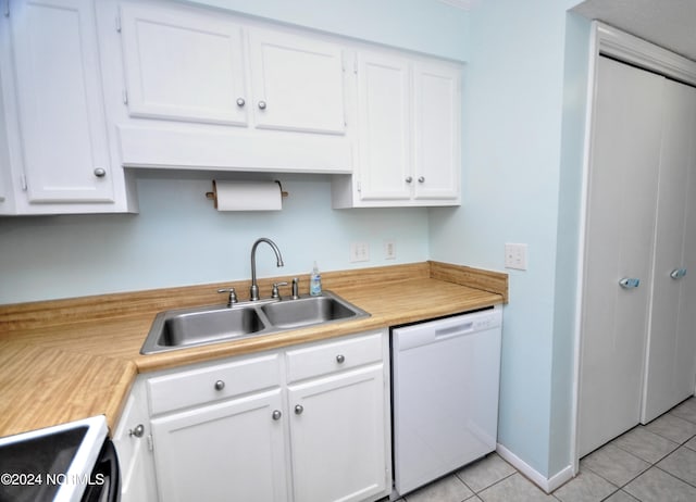 kitchen featuring sink, light tile patterned flooring, white dishwasher, white cabinets, and range