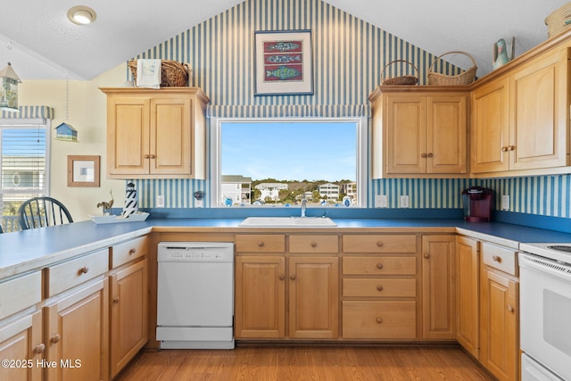 kitchen with sink, a textured ceiling, lofted ceiling, white appliances, and light wood-type flooring