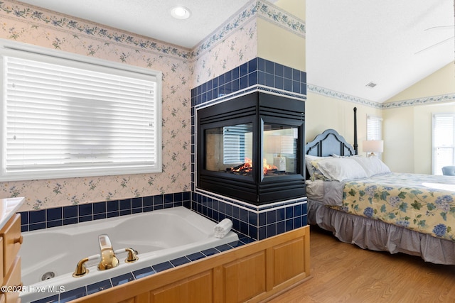 bathroom featuring hardwood / wood-style flooring, a bathtub, and a textured ceiling