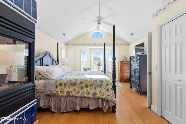 bedroom featuring hardwood / wood-style floors, ceiling fan, vaulted ceiling, and a closet