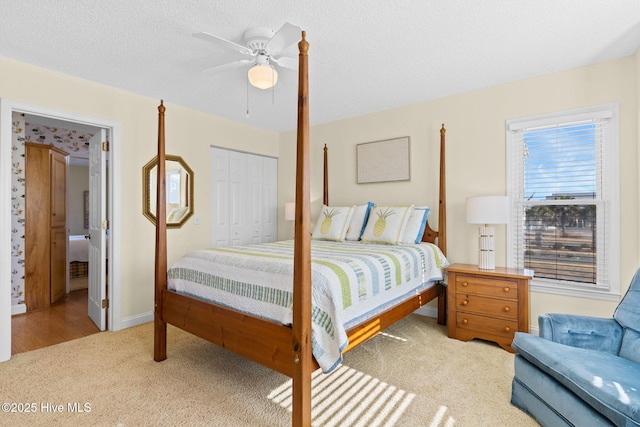 carpeted bedroom featuring ceiling fan, a textured ceiling, and a closet