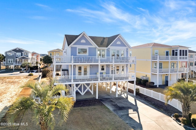 view of front facade featuring french doors, a balcony, a carport, and central air condition unit