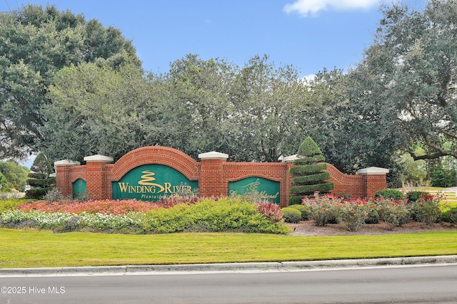 community / neighborhood sign featuring a yard