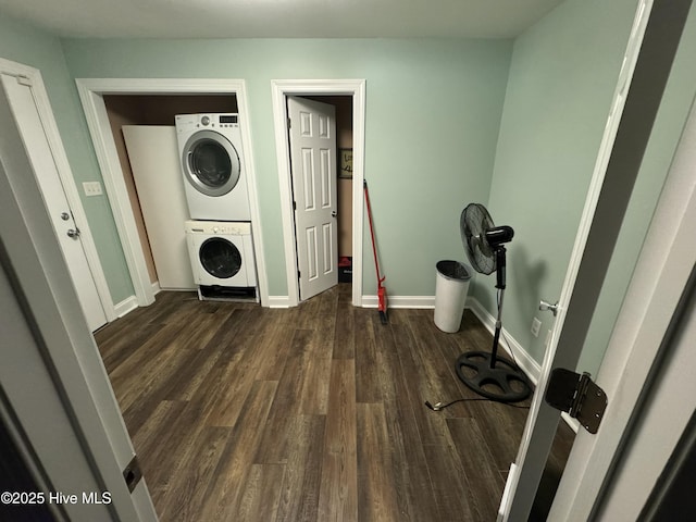 clothes washing area featuring dark hardwood / wood-style floors and stacked washer / dryer