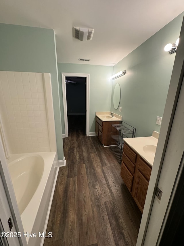 bathroom featuring a bathing tub, vanity, and hardwood / wood-style flooring