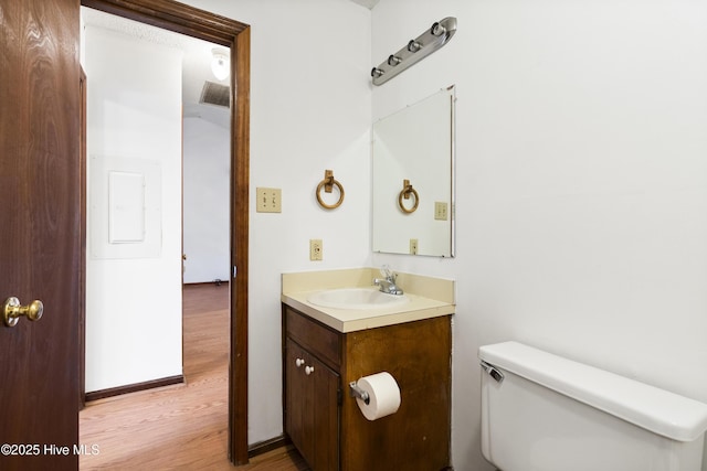 bathroom with hardwood / wood-style flooring, vanity, and toilet