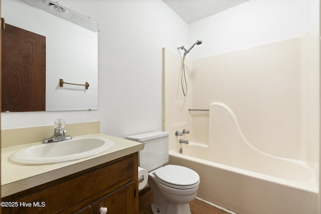 full bathroom featuring vanity, shower / tub combination, a textured ceiling, and toilet