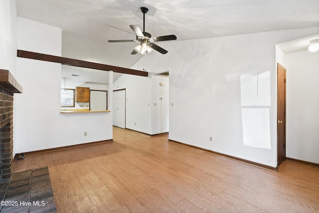 unfurnished living room with ceiling fan, light hardwood / wood-style floors, a fireplace, and vaulted ceiling