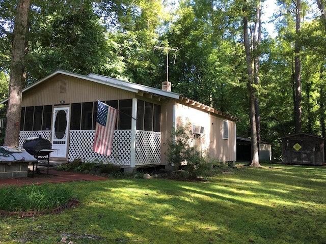 back of property with a lawn and a sunroom