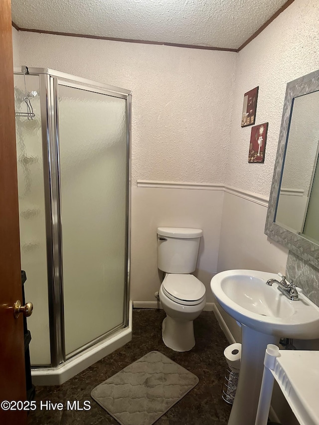 bathroom featuring toilet, crown molding, a textured ceiling, an enclosed shower, and sink