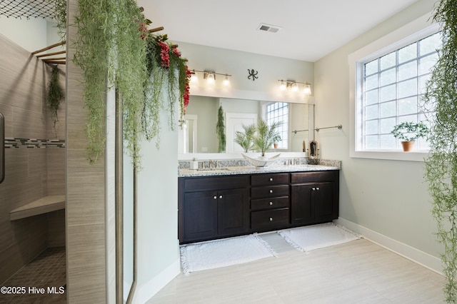 bathroom featuring a shower, plenty of natural light, and vanity