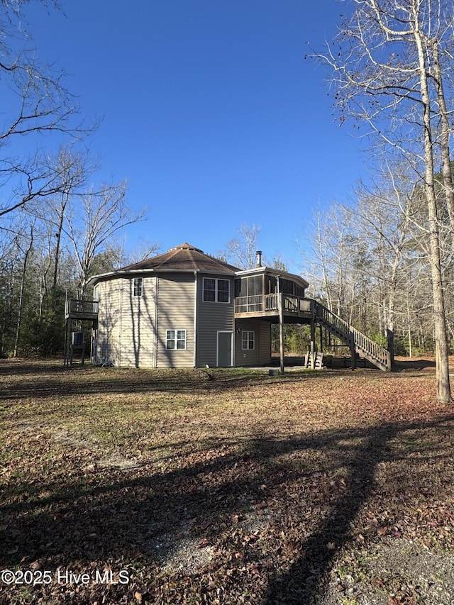 rear view of house with a sunroom and a deck