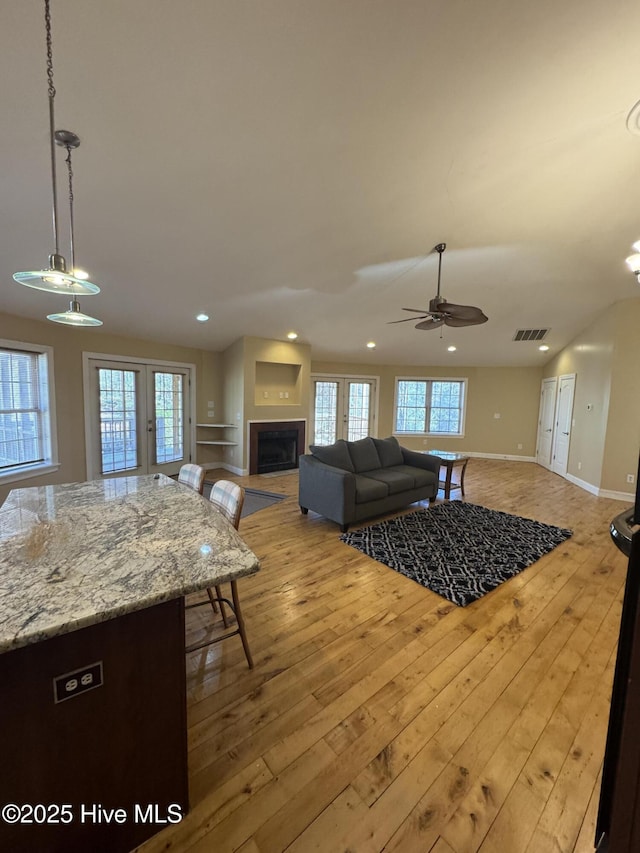 living room with french doors, light hardwood / wood-style floors, and ceiling fan