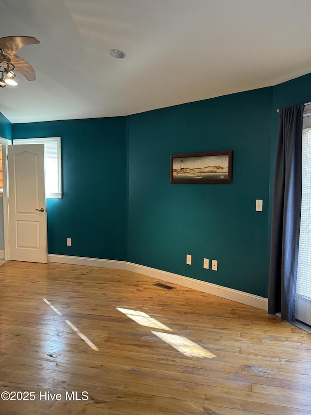 unfurnished room with ceiling fan, a wealth of natural light, and light hardwood / wood-style flooring