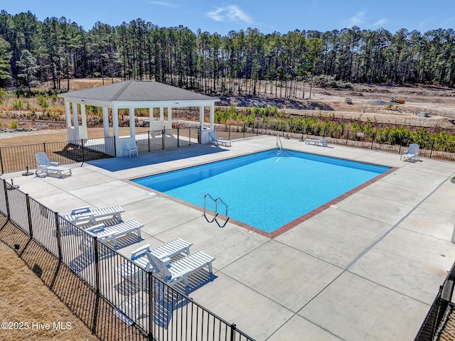 community pool with a gazebo, a patio area, and fence