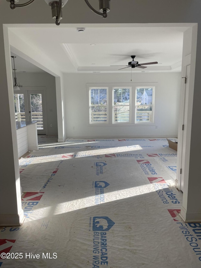 interior space with french doors, a raised ceiling, and a ceiling fan