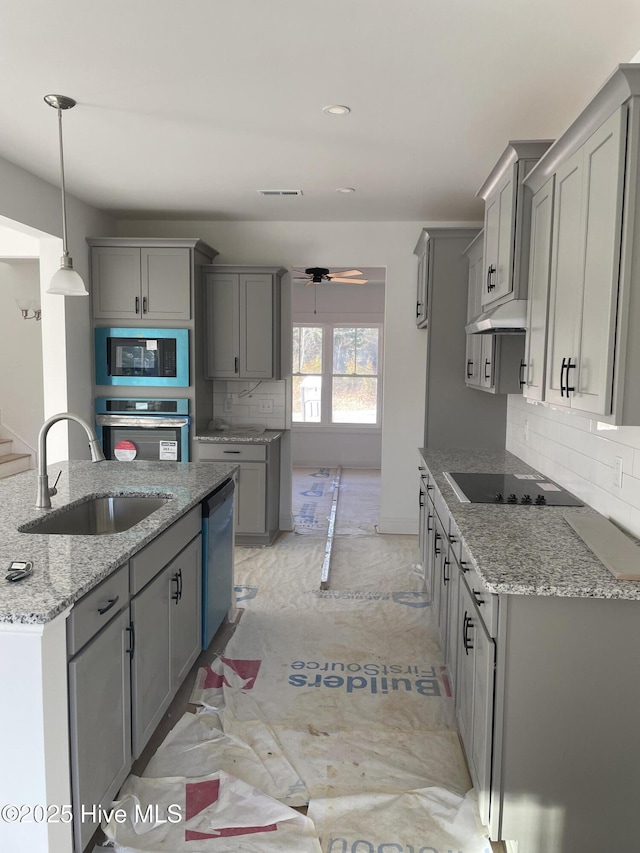 kitchen with visible vents, backsplash, gray cabinets, black appliances, and a sink