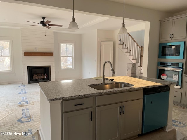 kitchen with gray cabinetry, a sink, stainless steel oven, built in microwave, and dishwasher