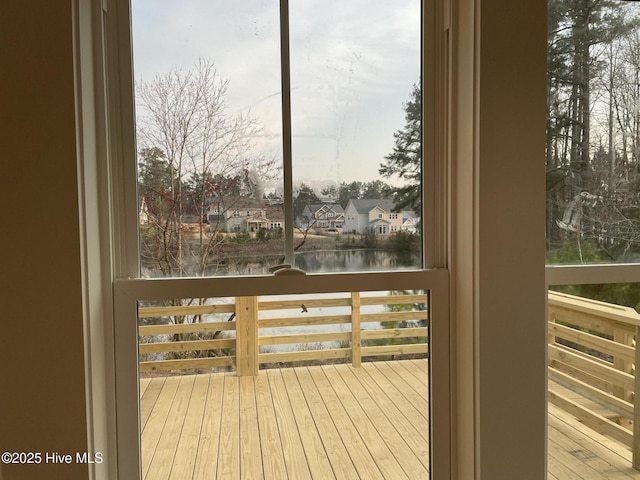 wooden terrace with a residential view and a water view