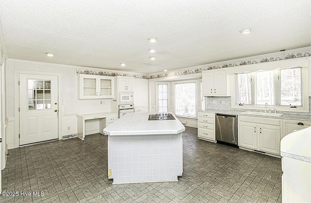 kitchen featuring a center island, white appliances, sink, and white cabinetry