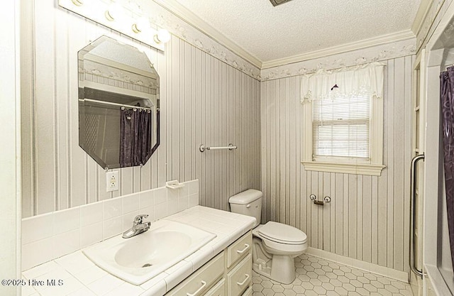 bathroom with vanity, crown molding, toilet, a textured ceiling, and curtained shower