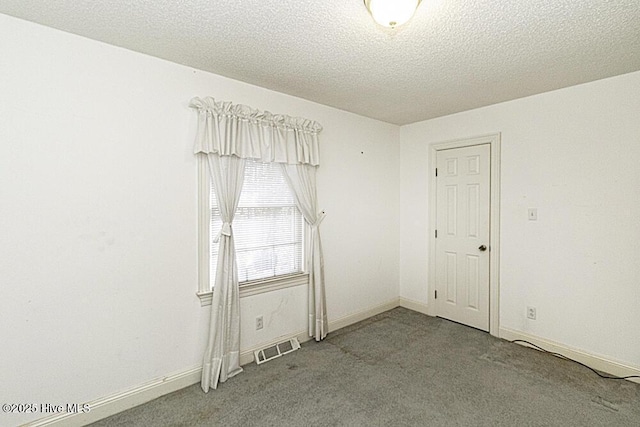 empty room with carpet and a textured ceiling