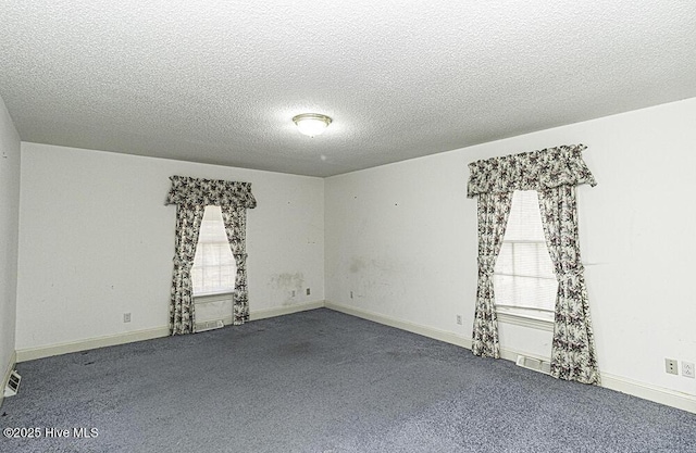 carpeted spare room with a textured ceiling