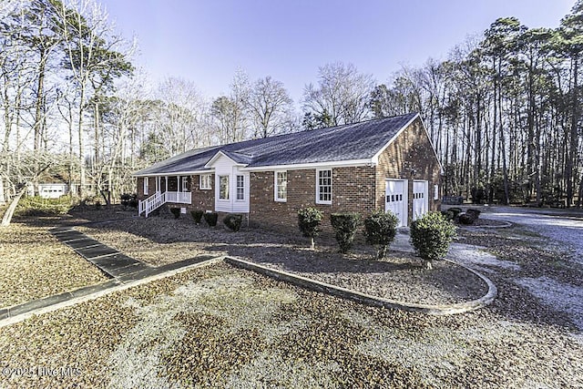 view of side of home featuring a porch and a garage