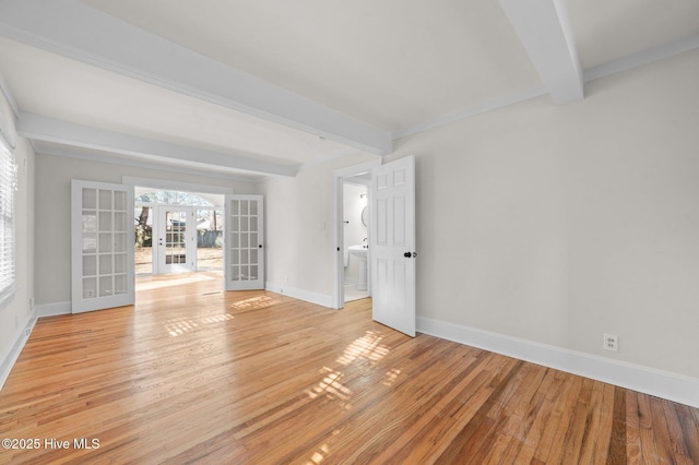 unfurnished room featuring beamed ceiling, french doors, and light hardwood / wood-style flooring