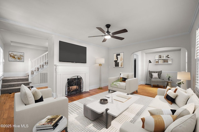 living room with hardwood / wood-style floors, ceiling fan, and crown molding