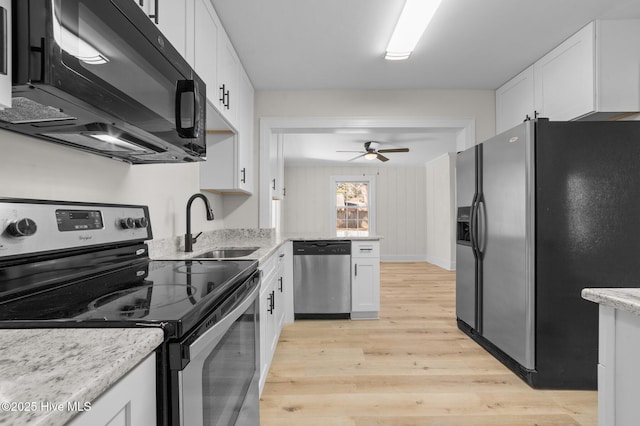 kitchen featuring black appliances, light stone counters, white cabinetry, and sink