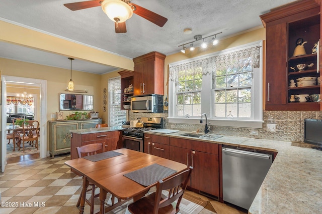 kitchen with pendant lighting, appliances with stainless steel finishes, sink, and backsplash