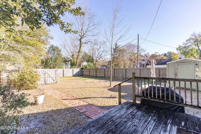 view of yard featuring a wooden deck and a storage unit