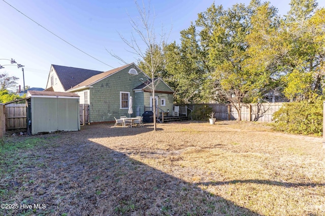 rear view of property with a yard and a storage shed